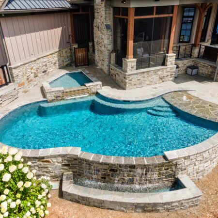 a pool on the corner of a house with spa