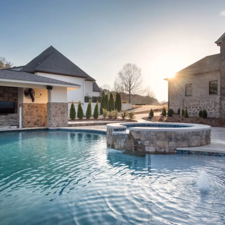 sun rising over freeform pool with above ground spa and bubbler fountain