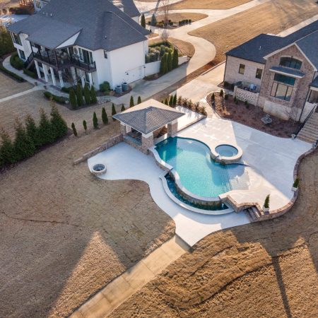 curvy freeform swimming pool in backyard