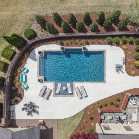 geometric pool from above in green backyard
