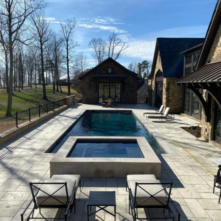 an above ground spa next to rectangle shaped swimming pool